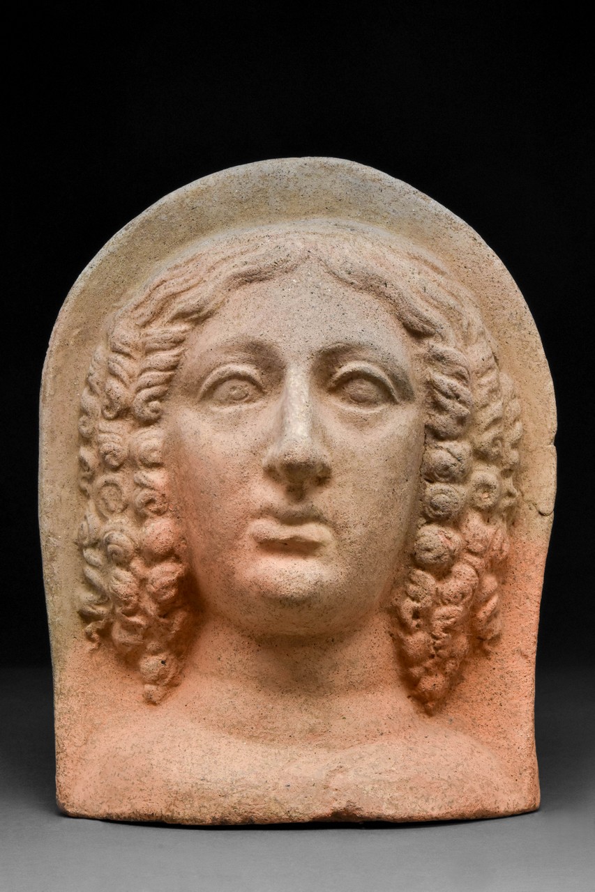 AN ETRUSCAN TERRACOTTA VOTIVE HEAD OF A WOMAN