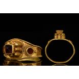 BYZANTINE GOLD TRUMPET RING WITH GARNETS