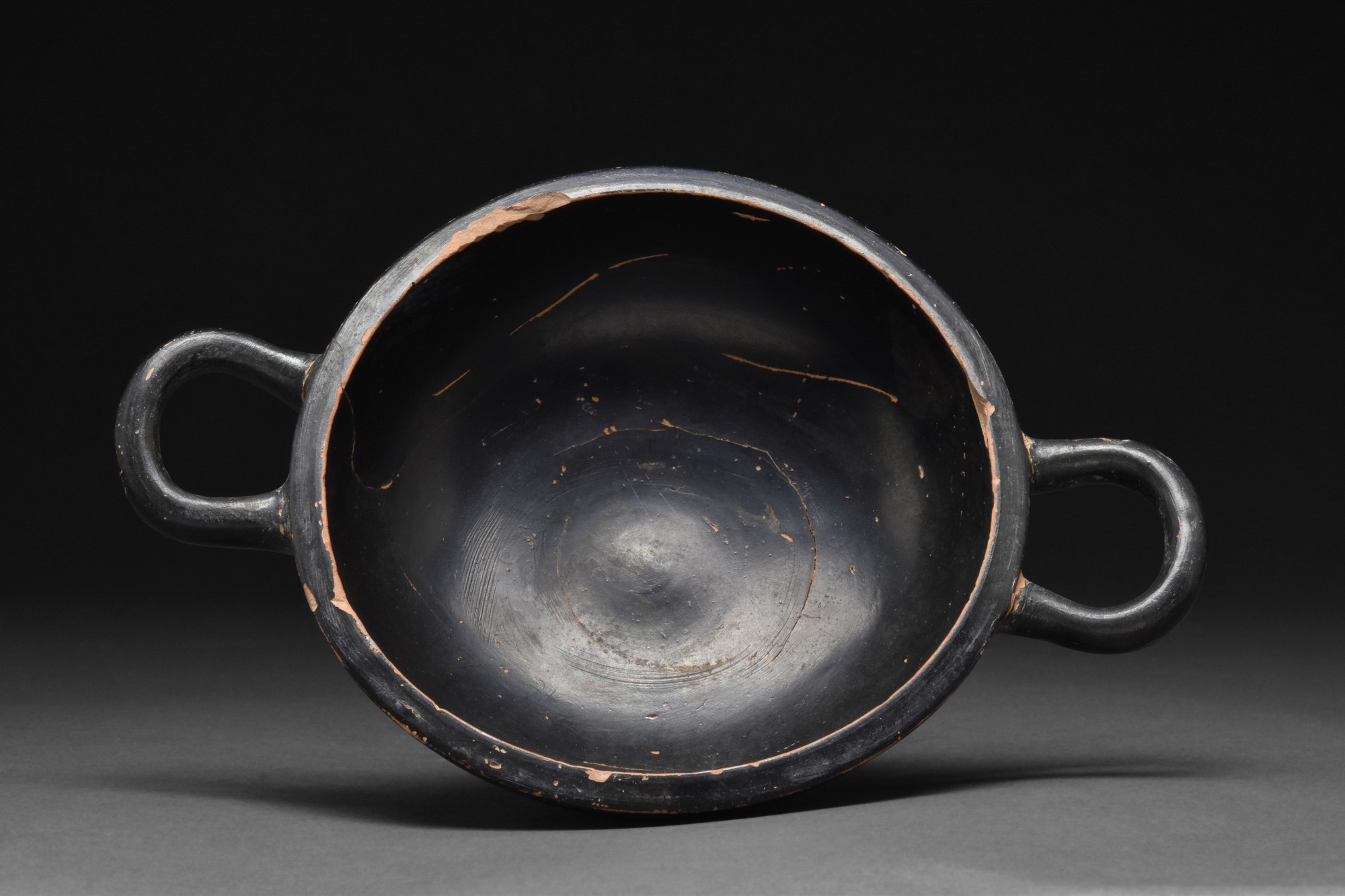 GREEK BLACK GLAZED TERRACOTTA TWO-HANDLED KYLIX