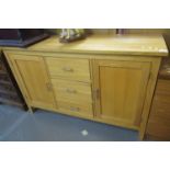Good quality natural ash sideboard with two blind panelled doors flanking three centre drawers.