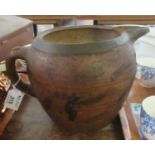 A rustic terracotta baluster shaped teapot or jug with painted banded decoration, and loop handle.