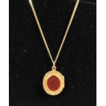 9ct gold locket and chain. The engraved locket inset with bloodstone and carnelian on a 9ct gold