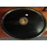 19th Century Pontypool style black Japanned metal oval tray with gilded decoration, the centre