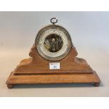Aneroid hanging brass barometer with silvered face and glass thermometer on a shaped and moulded