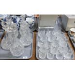 Two trays of cut glass. One tray with five cut glass decanters: a mallet shaped decanter, two