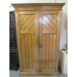 Late 19th/early 20th Century pitch pine, two door, blind panelled gentleman's wardrobe on platform