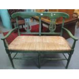 Painted two seater, open arm, lyre back seat or bench with rush seat on turned, tapering legs. (B.P.