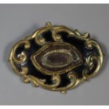 A Victorian mourning brooch decorated in black enamel with locket section to the front. Dated