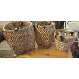 Graduated set of three modern two-handled wicker baskets with leather finish straps. With label '