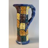 20th Century art pottery straight sided multi-coloured checked design jug with entwined handle. (B.