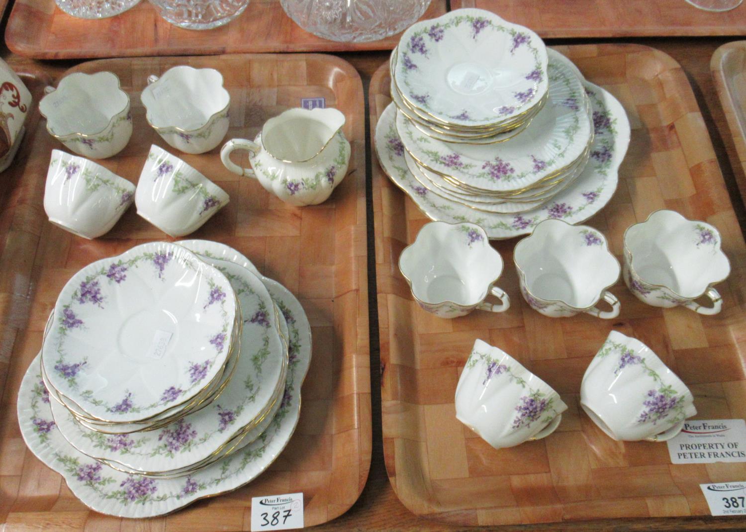 Two trays of Foley bone china teaware decorated with Wisteria blossom on a white ground with gilt