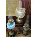 Three early 20th Century double oil lamps, one with a blue opaline glass moulded floral and