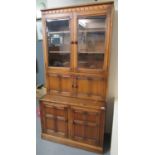Elm Ercol two stage kitchen cabinet on a projecting base with two blind panelled doors, with gold