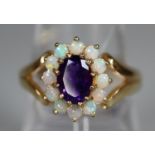 9ct gold dress ring set with an oval amethyst surrounded by opals. Ring size O. Approx weight 3.5