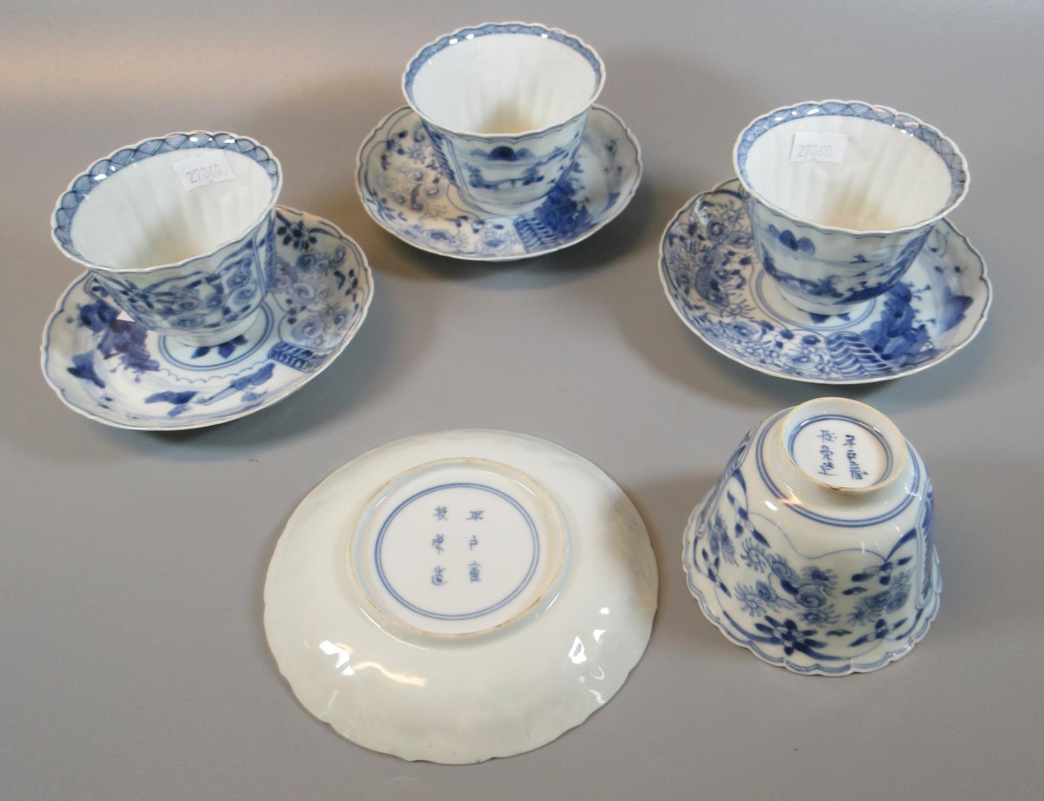 Set of four blue and white porcelain tea bowls and saucers moulded and painted with landscapes and