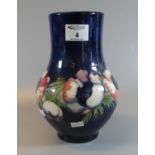 Moorcroft art pottery tube lined anemone pattern blue ground vase of baluster form. 23cm high