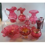 A collection of mainly Victorian cranberry glass items to include; jugs, vases, hand bell, basket