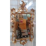 19th century style gilded mirror with carved floral and foliate decoration (modern). 105 x 57cm