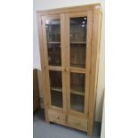 Modern pine two door glazed bookcase or display cabinet with under drawers. 82 x 35 x 179cm