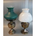 Two similar oil burner lamps with opaline glass shades on brass reservoir and base. (2) (B.P.