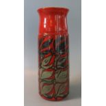 Poole pottery vase of tapering conical form on a red ground with stylised foliage. Impressed and