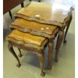 Set of three reproduction walnut serpentine design nest of tables with glass tops, standing on