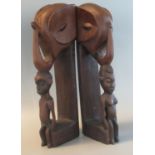 Pair of African tribal design hardwood book ends in the form of figures and elephants head. 42cm