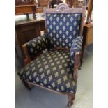 Edwardian walnut framed upholstered open arm chair on turned legs and castors. (B.P. 21% + VAT)