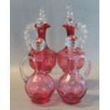 Pair of Victorian cranberry glass baluster-shaped single handled decanters with stoppers, together