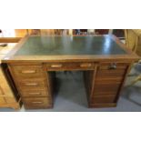 Early 20th century oak knee hole desk with leather insert top above one tambour pedestal, the
