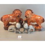 Pair of Hanley Staffordshire pottery fireside lions, both standing with one foot on a ball (one