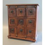 Small, hardwood table top specimen chest having a bank of nine square drawers with metal ring loop