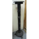 19th century ebonised torchere stand decorated with trailing leaves and standing on paw feet. (B.
