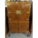 Mid century walnut two-stage blind paneled cocktail cabinet with shaped and carved frieze on