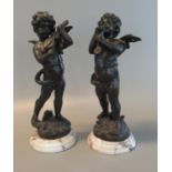 Pair of classical style patterned bronze cherubs, playing musical instruments, on circular marble