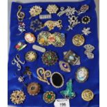 Collection of vintage brooches of various designs including cameo, commemorative, leaf, floral,