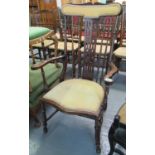 Edwardian mahogany slat and spindle back high open armchair with serpentine seat on turned legs. (