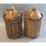 Two vintage stone ware flagons, Catterali Swarbricks, The Stores, Blackpool. Both in wicker