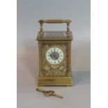 Large French gilt brass carriage clock with Arabic ceramic dial set in a pierced foliate frame work.
