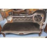 Victorian rosewood button-back upholstered chaise lounge with ornately carved scroll arm, the carved