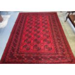 Red ground Afghan double knot carpet with traditional bokhara design. 335 x 258cm approximately. (