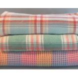 Two multicoloured striped and checked blankets, together with a multicoloured honey comb blanket. (