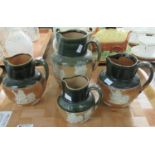 Four Royal Doulton stonewear Whisky Jugs in green, brown and cream, (two marked Doulton Lambeth) (
