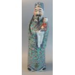 Chinese porcelain standing male figure of an imortal holding a child (symbol of longevity). 20th