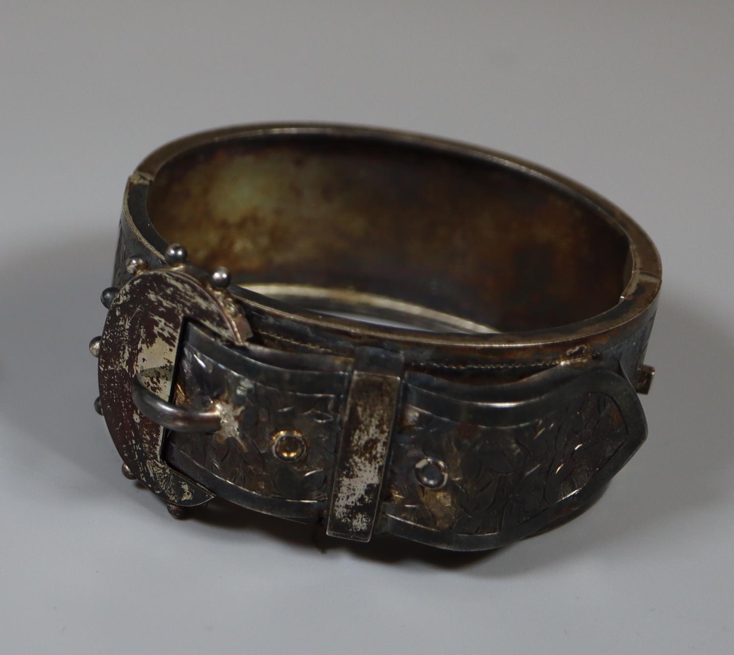 A large Victorian buckle bangle engraved with foliage. Approx weight 40 grams. (B.P. 21% + VAT)