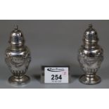 Pair of late Victorian silver pepperettes with ribbon and swag designs. Birmingham 1899. 2.5oz