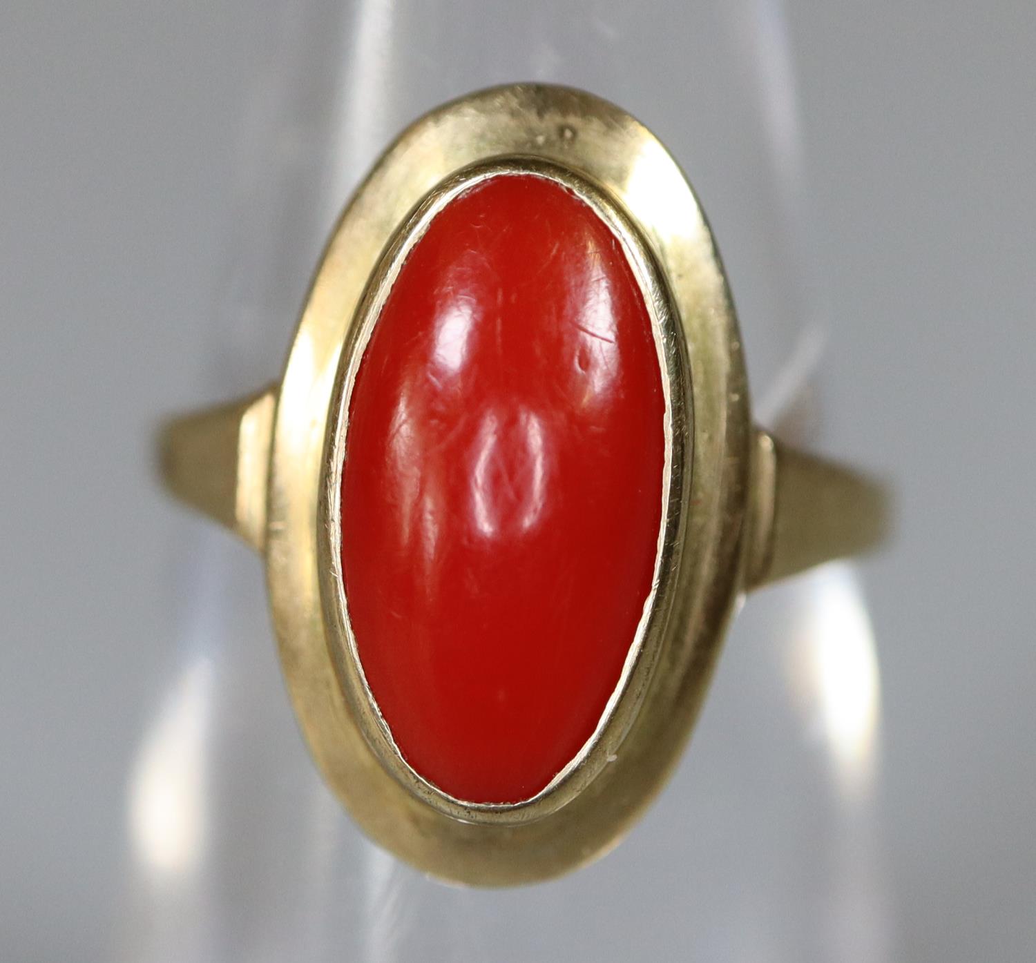 Yellow metal ring set with an oval red stone. Ring size J. Approx weight 2.1 grams. (B.P. 21% + VAT)