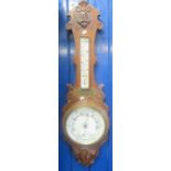 Edwardian oak aneroid wheel barometer with moulded and carved decoration and presentation plaque. (