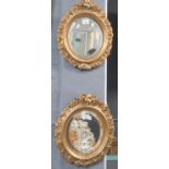 A pretty pair of oval gilt framed bevelled wall mirrors - the frames with flowers and fruit. Overall