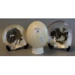 Ostrich egg, together with two mother of pearl shells with painted, decoration of cottage and